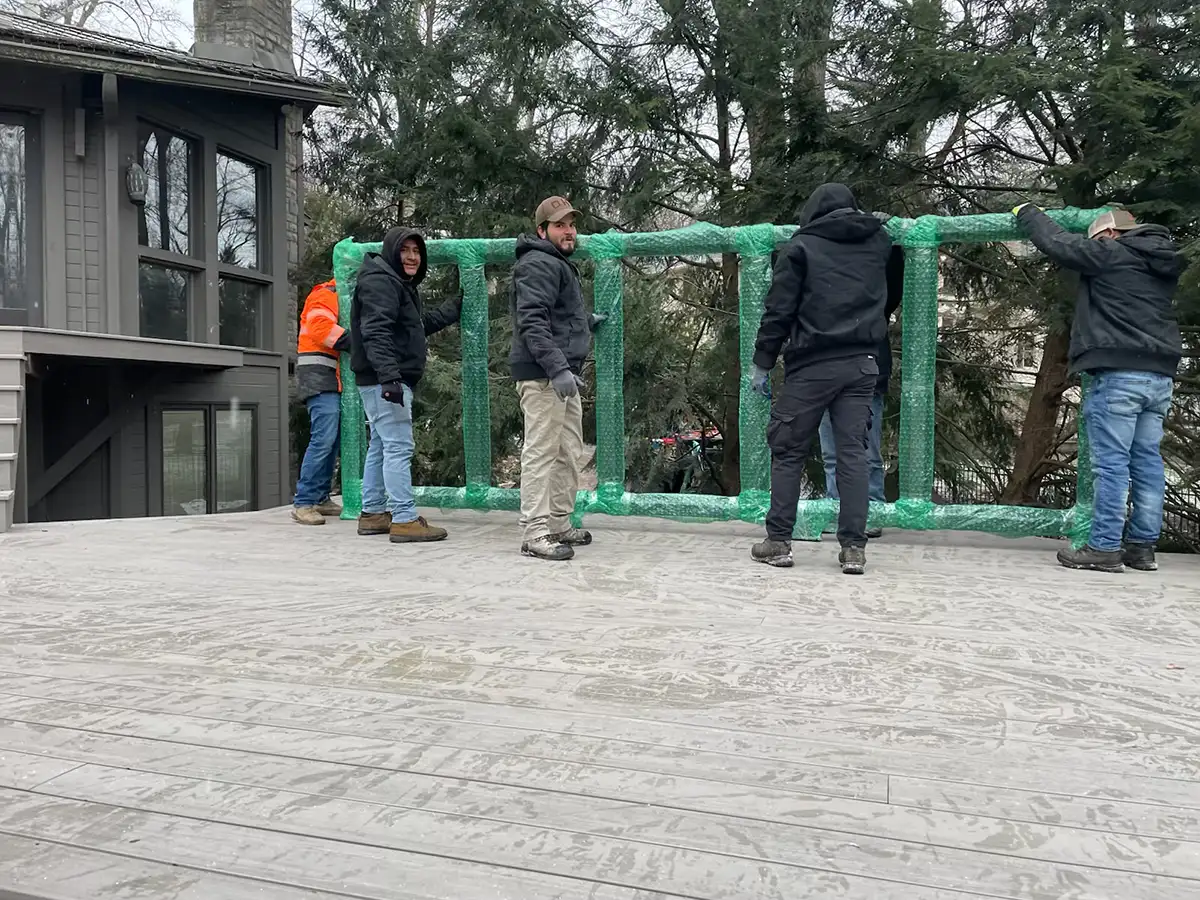 2 workers putting up patio barrier by Riepenhoff Landscape